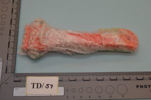 The glass hammer purchased by Howitt, it is orange in colour and wrapped in bubblewrap.
