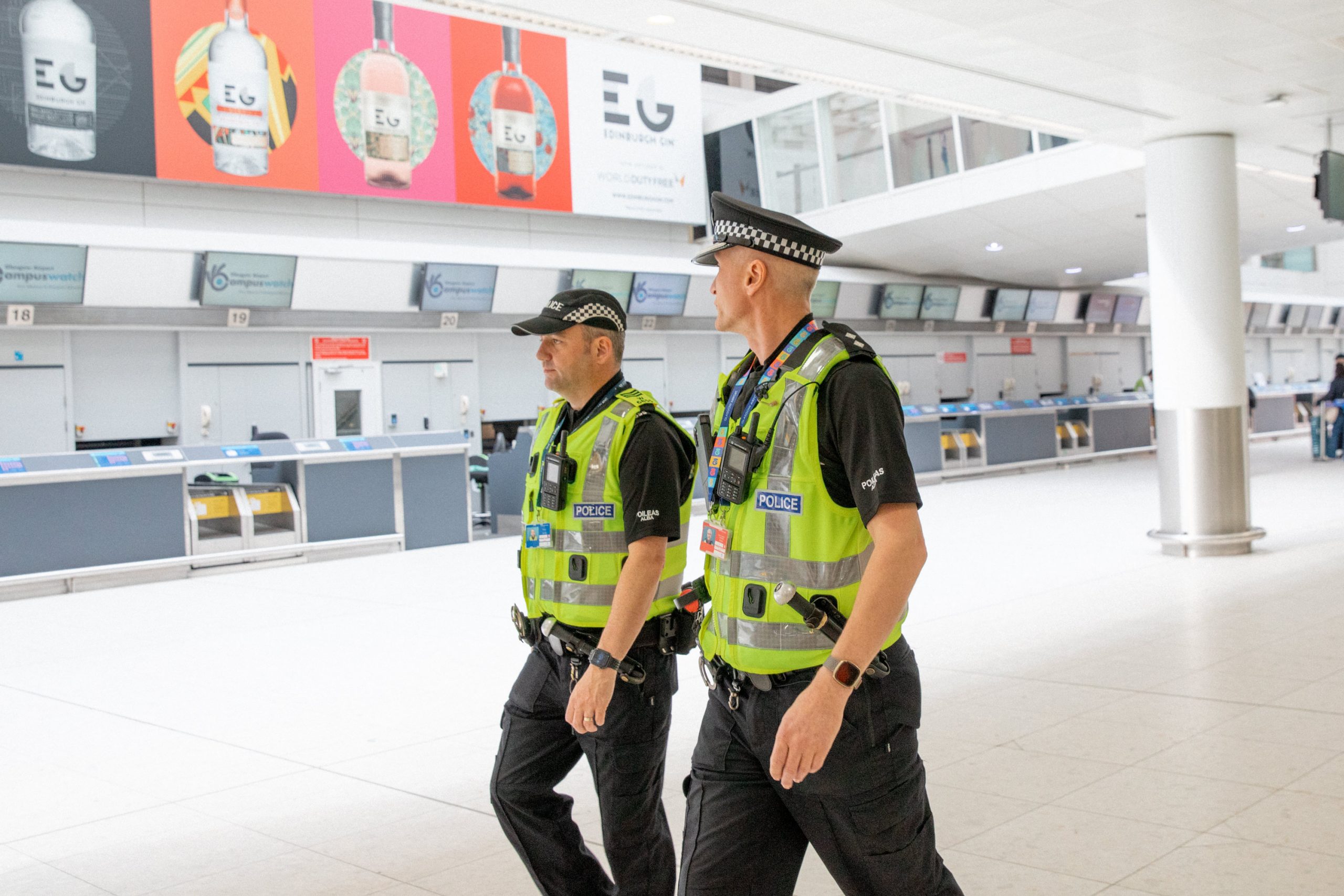 Two Police Officers walking through an airport.