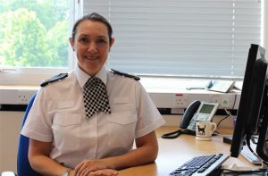 ACC Vicki Evans sat at a desk in uniform